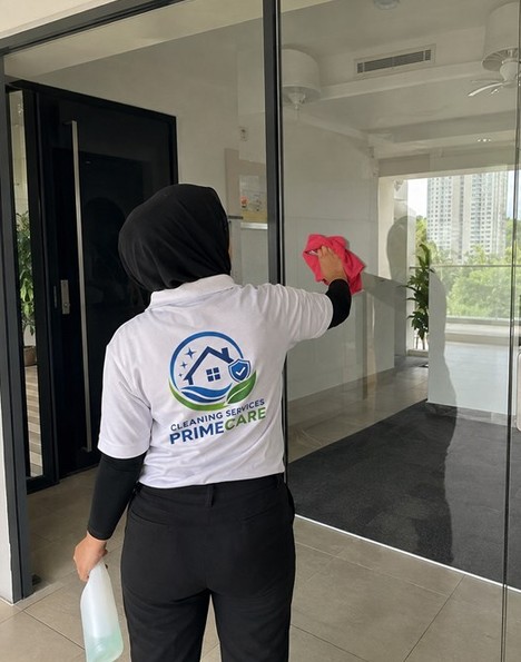 Cleaning Services Primecare cleaner wiping glass doors at a Malaysian office