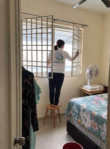 Cleaning Services Primecare cleaner wiping window grilles in a bedroom
